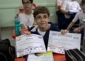 aluno do fundamental II com os certificados da OBA e da MOBFOG